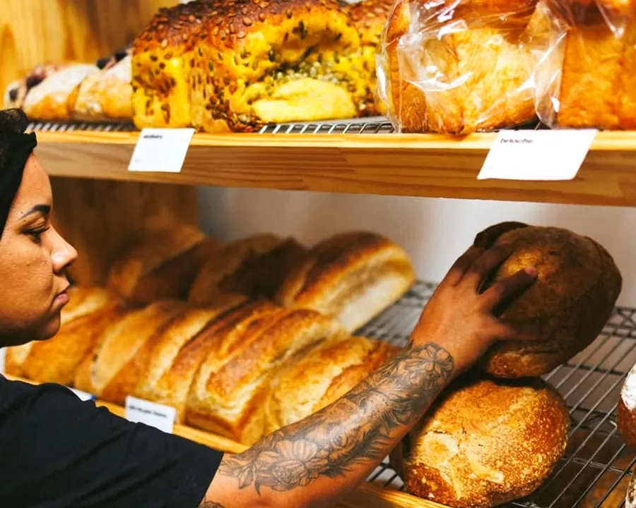 Atendente organizando os pães na vitrine